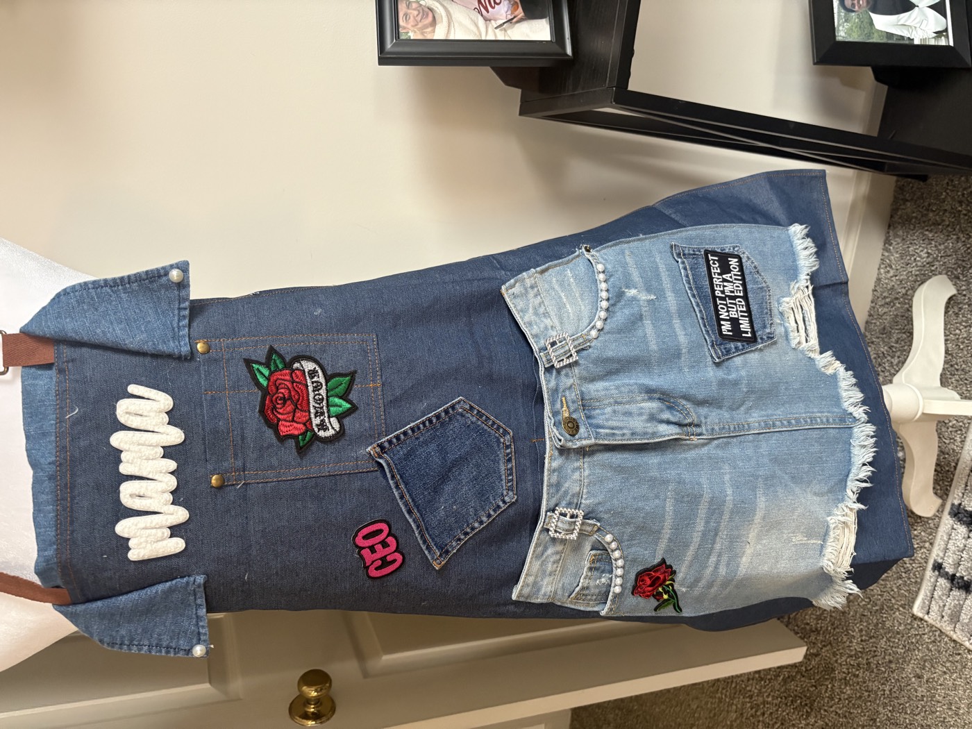 Denim apron with Mama in white lettering, a rose patch, a CEO patch and a distressed jeans-front pocket panel.